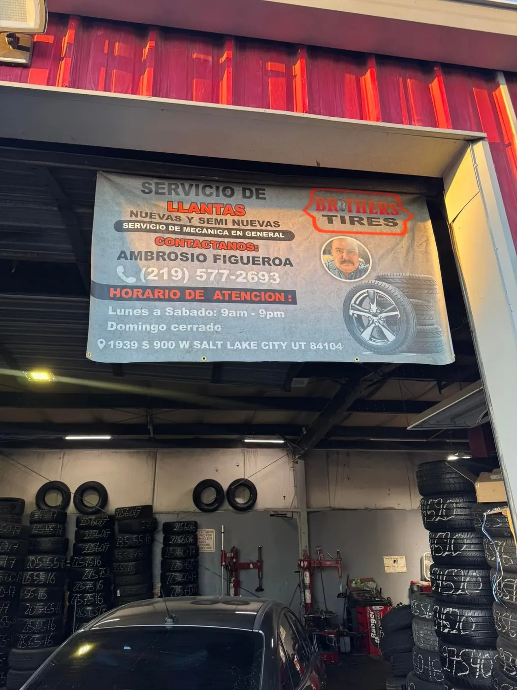 Inside the shop with racks of tires along the wall